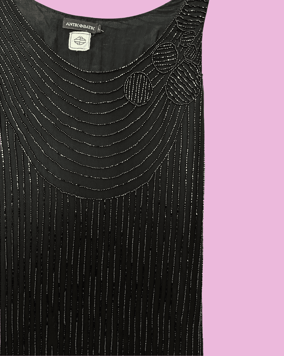 Close-up of curved black beadwork and the floral shoulder detail on a black mini dress