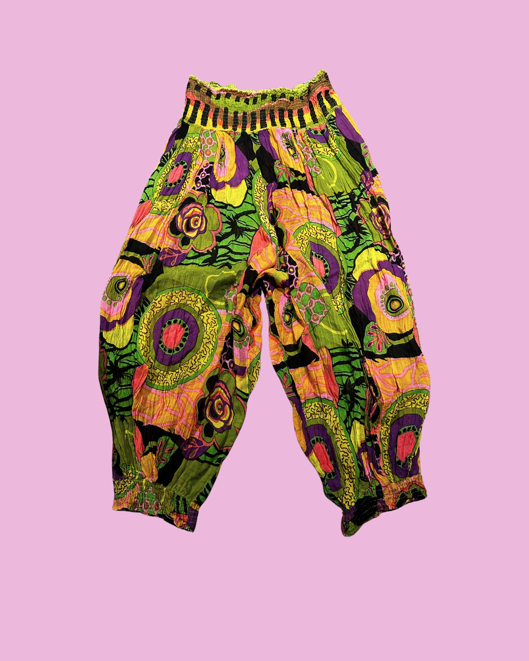 Loose colourful trousers with a psychedelic floral print, gathered waistband and gathered ankle cuffs