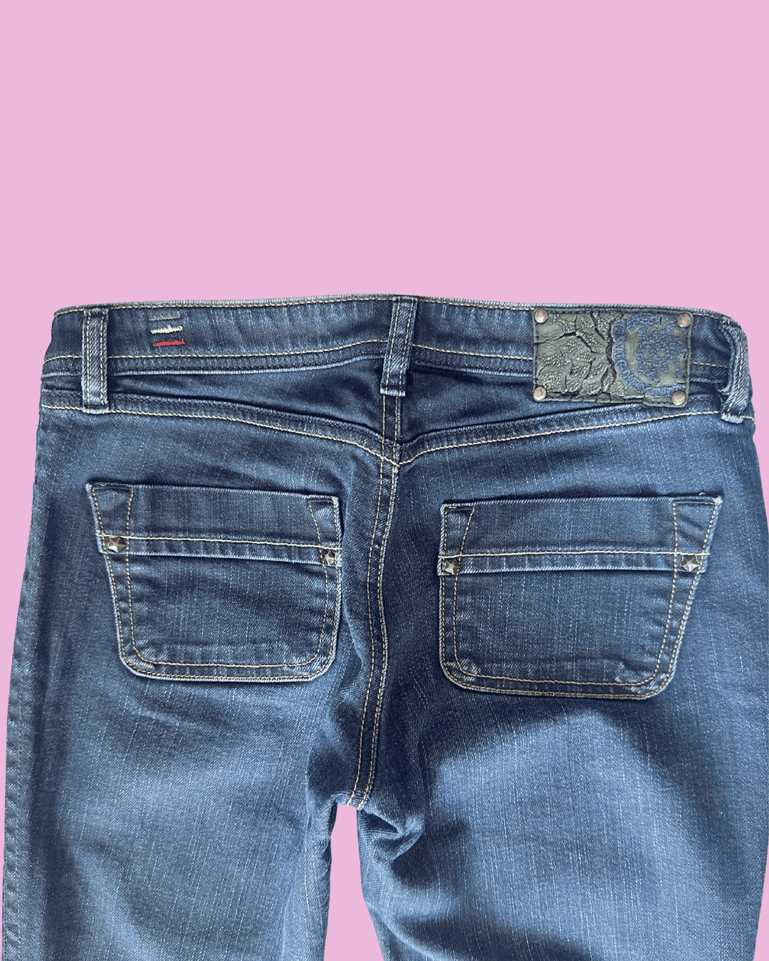 Original rear detail photo of jeans showing the waistband patch, belt loops, back flap pockets and contrast stitching